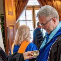 faculty looking at medal